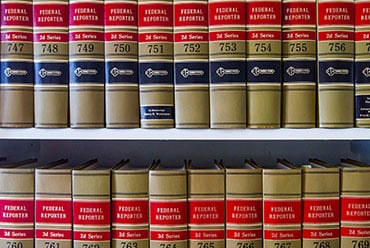 Rows of law books on a shelf, labeled 'Federal Reporter'.